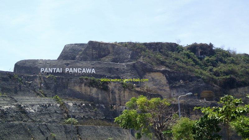 Sign of Pandawa Beach, Bali, on a high cliff overlooking the entrance to the beach area.