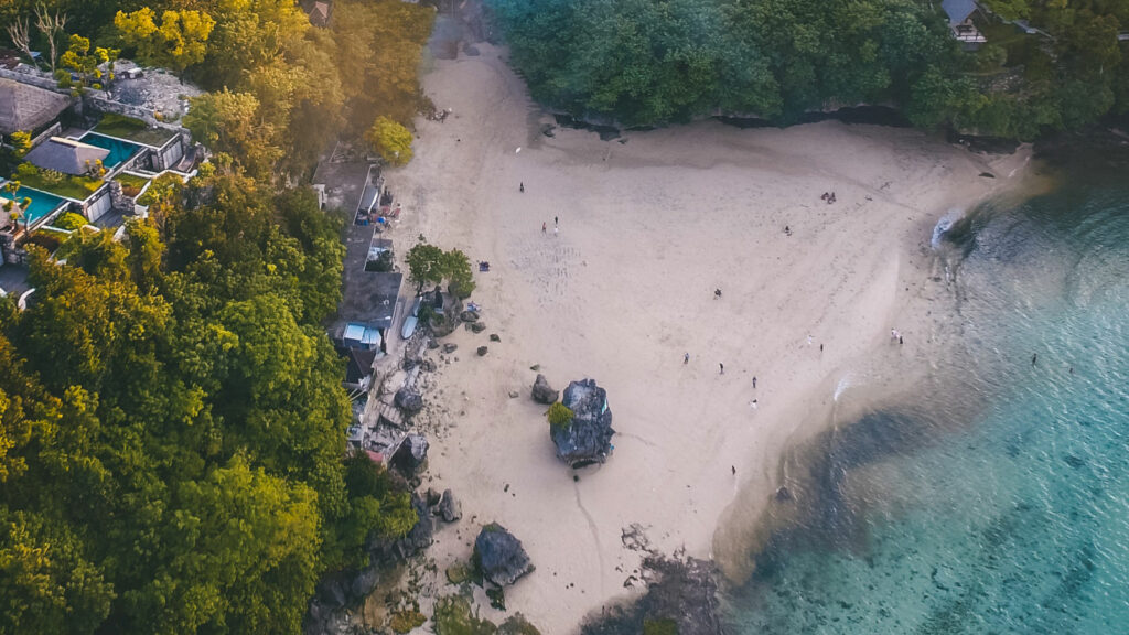 Aerial view of Padang Padang Beach showcasing its tranquil morning atmosphere with minimal crowds.