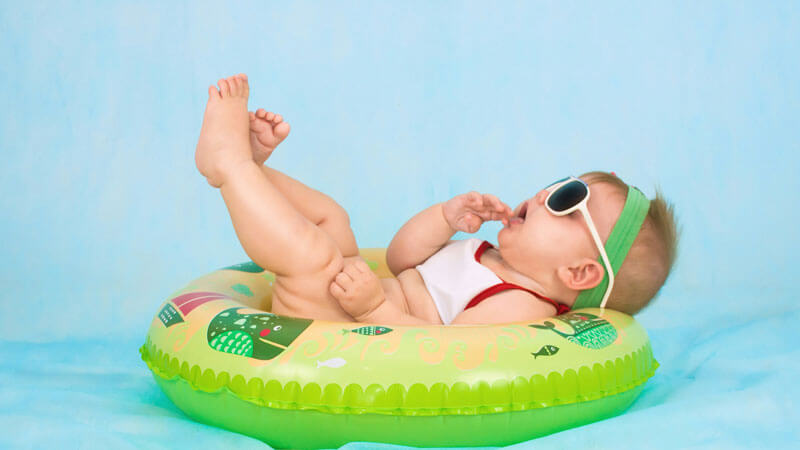 Cute toddler playing with a float on Bali beach. Travel Tips To Bali With Toddlers, Babies, and Children