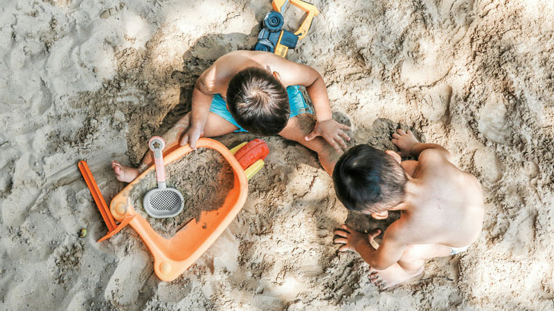 Children playing in the sand on the beach - Travel Tips To Bali With Toddlers, Babies, and Children