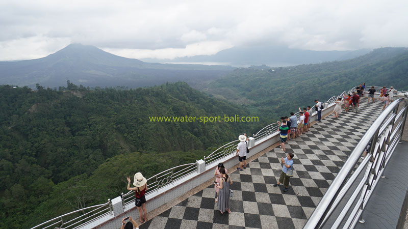 Visitors on the viewing deck overlooking the panoramic vista of Mount Batur in Kintamani, Bali