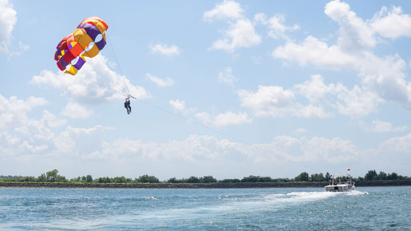 Parasailing participants enjoyed views of the blue sea above Tanjung Benoa, Bali. FAQ Parasailing Bali