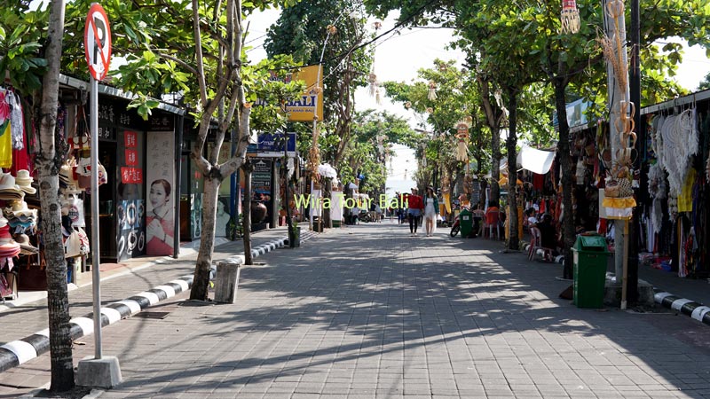 Street view of the shopping area near Tanah Lot Temple, lined with shops and trees