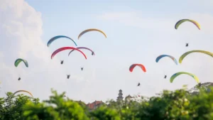 Paragliding in Bali: colorful paragliders across the sky.