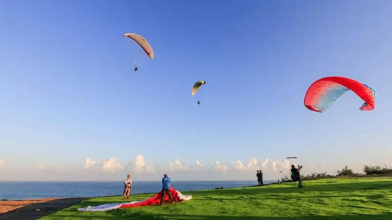 Paragliding canopy laid out on a coastal takeoff field.