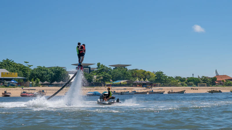 Watersport enthusiasts enjoying flyboarding at Tanjung Benoa Beach.