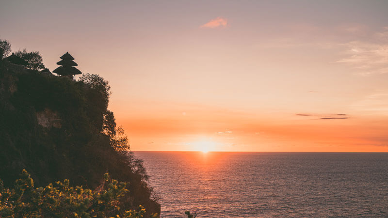 Breathtaking sunset view at Uluwatu Temple overlooking the vast ocean, a must-see attraction in Bali