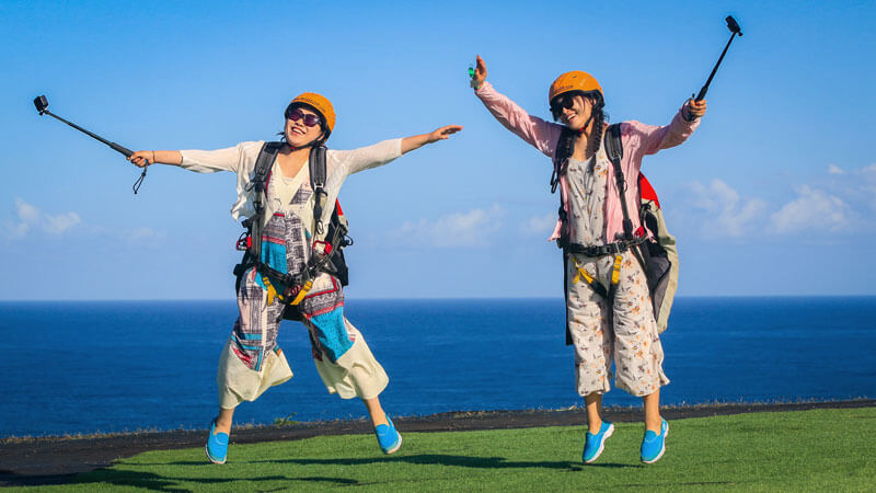 Young adults participating in unforgettable activities in Bali, including Bali Paragliding Riug Cliff Uluwatu adventures.