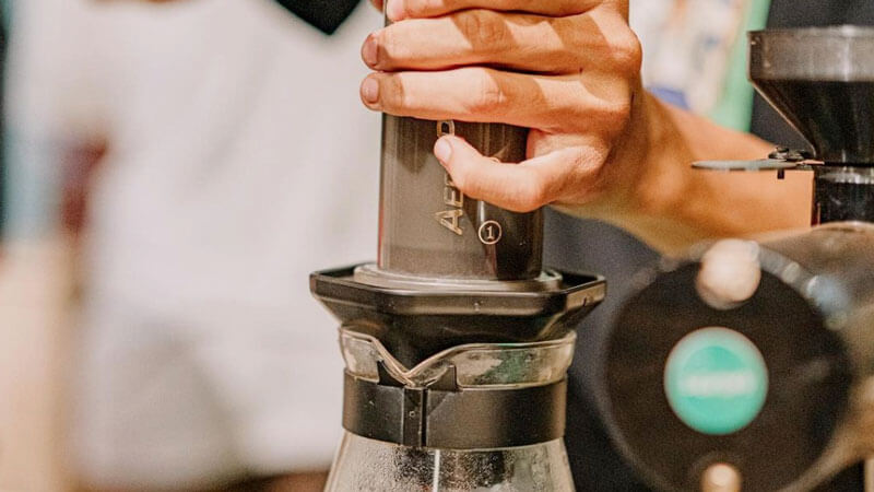 Barista's hands carefully prepare fresh coffee at Sekopi.Renon cafe