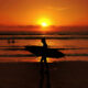 Sunset view at Legian Beach, Bali with surfers in the distance