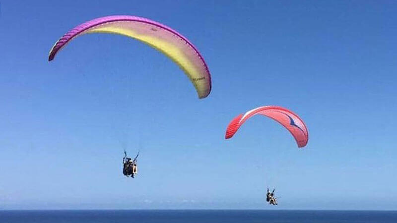 Paragliders gliding over the ocean near Timbis Cliff, Bali