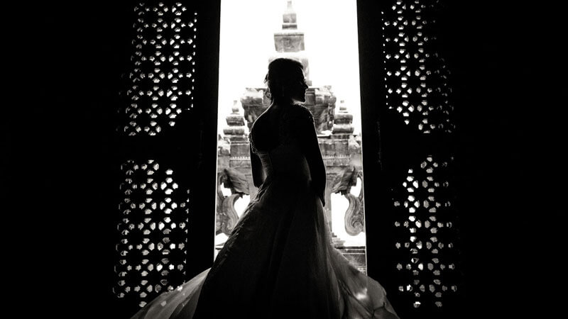 Silhouette of a bride gazing at Bajra Sandhi Monument's structure through ornate doors, symbolizing the blend of cultural heritage and personal milestones.