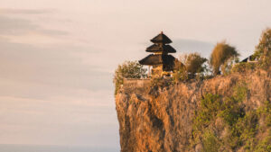 The serene Uluwatu Temple, Bali, perched on a cliff at sunset, overlooking the Indian Ocean.