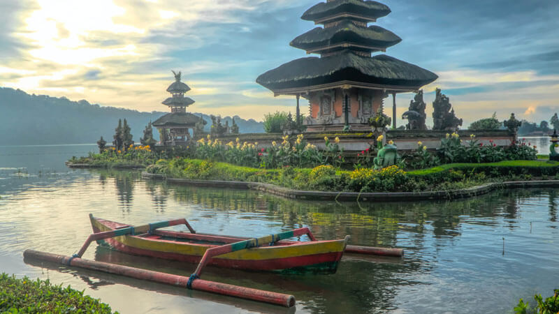 Traditional canoe floating on the calm waters of Lake Beratan near Ulun Danu Temple