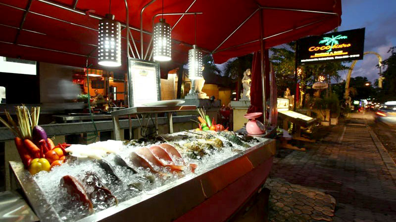 Fresh seafood display at Coco Bistro in Tanjung Benoa at dusk.