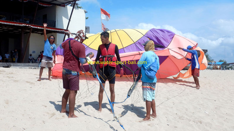 Solo Parasailing crew preparing equipment on beach in Bali