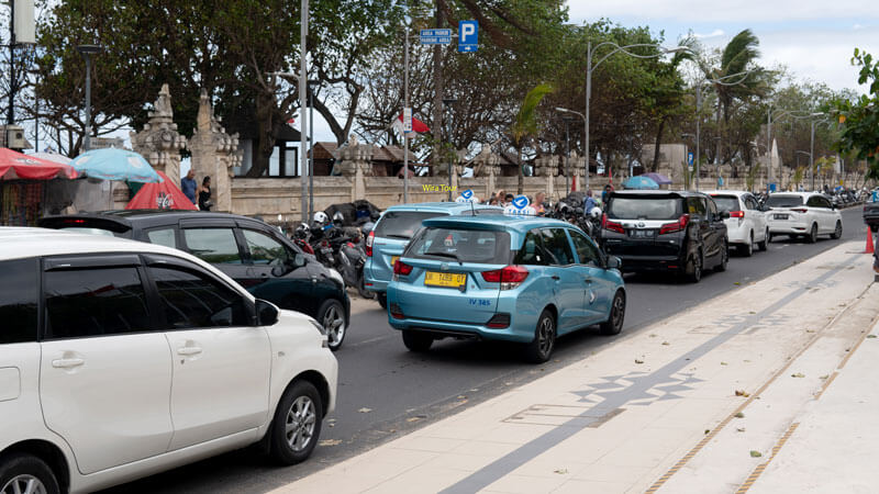 Busy traffic in Bali with visible Blue Bird taxis, illustrating transportation options