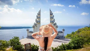 Tourist admiring Bali’s iconic oceanfront temple gate