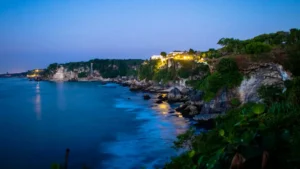 Dusk view of Uluwatu’s illuminated cliffs overlooking the ocean, Bali.