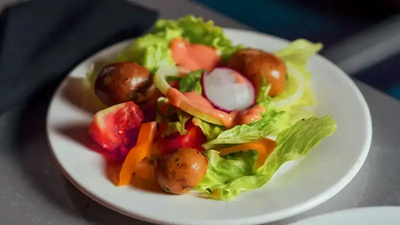 Fresh garden salad with potatoes, lettuce, and dressing served on a Bali luxury sunset dinner cruise.