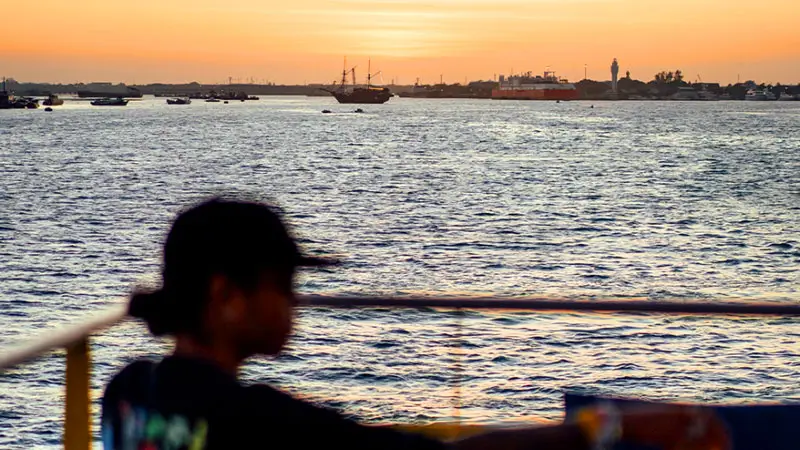 A guest enjoying ocean views from the open deck on a relaxing evening on a premium vessel.