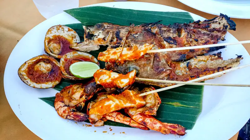 Grilled seafood platter served at a beachfront restaurant. © Wira Tour