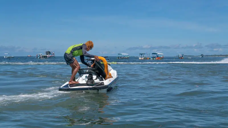 Jet Ski instructor in Bali prepares a watercraft before giving a safety briefing to first-time riders.