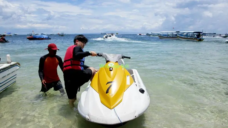 Beginner rider learning how to use a jet ski with instructor guidance at Tanjung Benoa Beach, Bali.