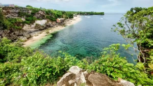 Aerial view of Balangan Beach Bali from the cliff, showing clear water, waves, and surf-friendly shoreline.