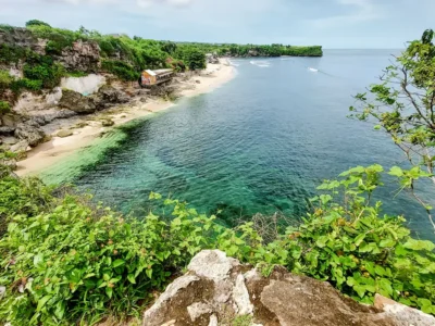 Aerial view of Balangan Beach Bali from the cliff, showing clear water, waves, and surf-friendly shoreline.