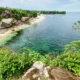 Aerial view of Balangan Beach Bali from the cliff, showing clear water, waves, and surf-friendly shoreline.