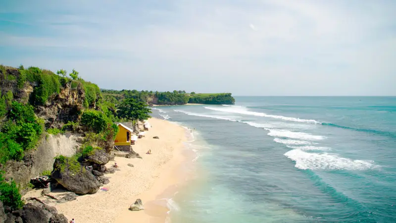 Cliffside view of Balangan Beach Bali with surf waves and golden sand.