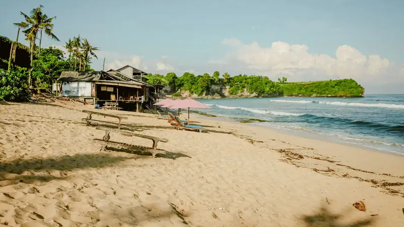 Local beachfront warung at Balangan Beach Bali with ocean view and surf waves in the background.