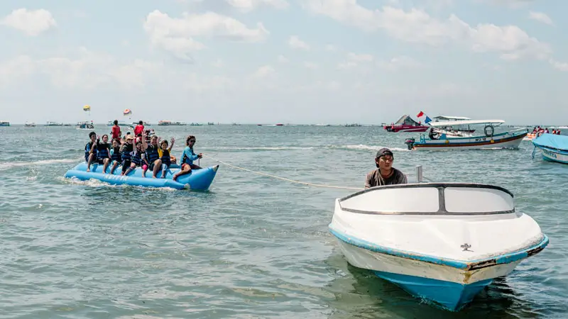 Family on banana boat as part of Turtle Island Banana Boat Parasailing Package in Bali