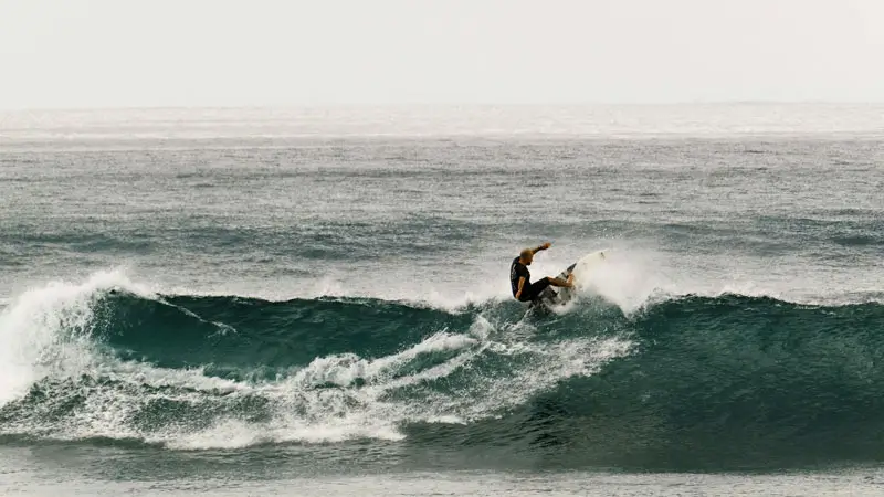 Intermediate surfer riding a left-hand wave at Balangan Beach Bali during dry season swell.