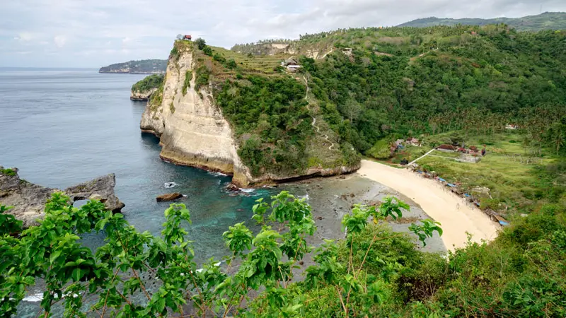 Steep trail leading to a quiet beach from a clifftop path, with no crowds in sight