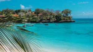 Tropical beach at Mushroom Bay in Nusa Lembongan with turquoise water and palm leaves