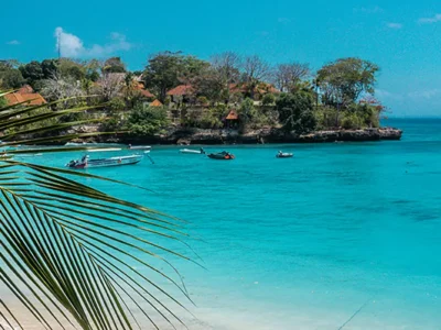 Tropical beach at Mushroom Bay in Nusa Lembongan with turquoise water and palm leaves
