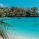 Tropical beach at Mushroom Bay in Nusa Lembongan with turquoise water and palm leaves