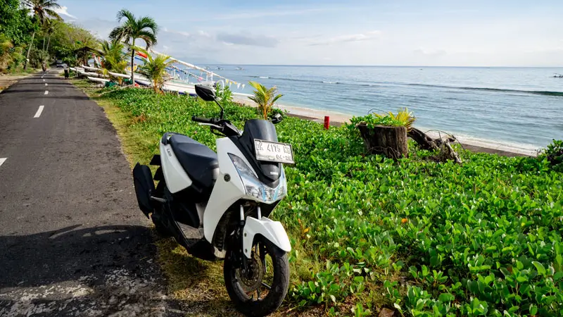 Scooter parked on a remote scenic road near cliff beaches in Bali