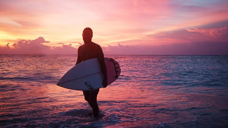 Silhouette of surfer at sunset on a Bali beach