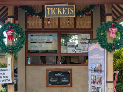 Penglipuran ticket counter with price board and hours sign 08:00–18:30 WITA