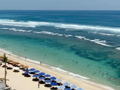 Clifftop overview of Melasti’s south-facing bay with reef and rows of daybeds sets expectations for first-timers.