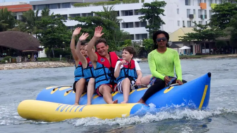 Family on banana boat in Bali wearing life jackets; beginner friendly