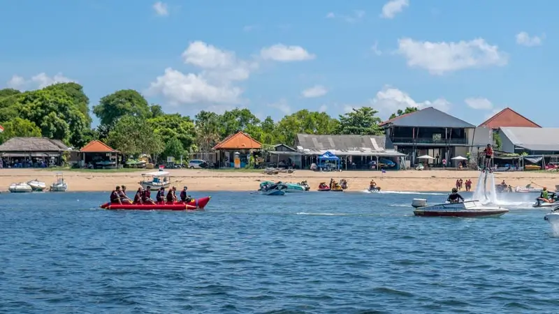 Group on a banana boat near a Bali beach in a water sports area.
