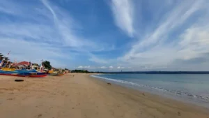 Wide view of Jimbaran Beach Bali with colorful fishing boats and calm sea