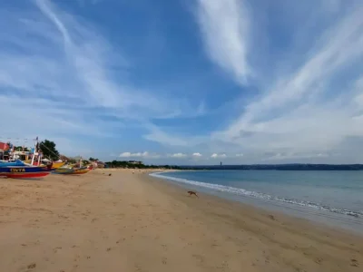 Wide view of Jimbaran Beach Bali with colorful fishing boats and calm sea