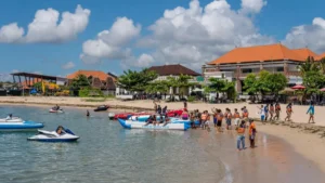Busy Tanjung Benoa banana boat launch with riders in life jackets and jet skis nearby
