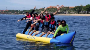 Family on a banana boat in Bali wearing life jackets during a gentle tow