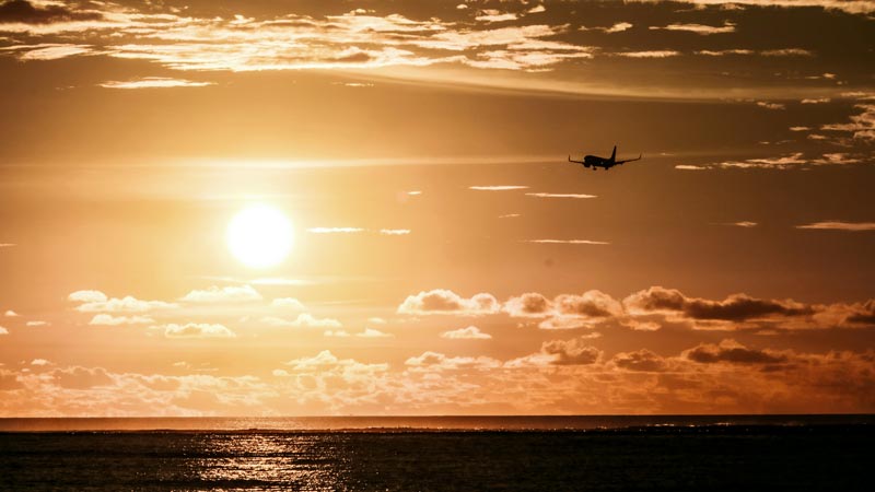Airplane landing over the sea at sunset near Jimbaran Bali